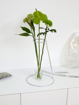 A zinc galvanized flower stand holding tall flowers only using a small glass standing on a shelf. ErtlundZull