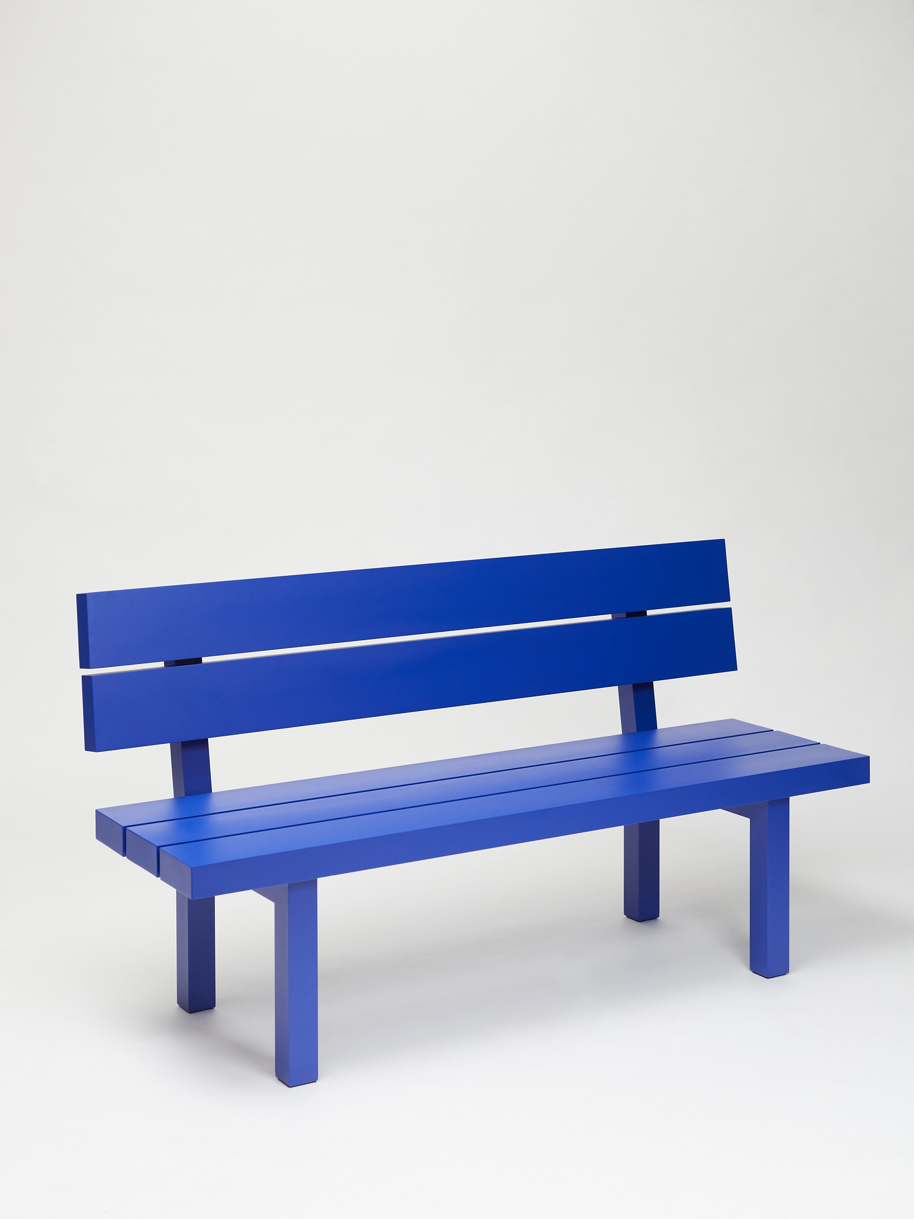 Big blue bench with backrest from the aluminium furniture series Pretending It's Wood in a white studio. Designed by ErtlundZull. Photographed by Robert Hamcher. ErtlundZull