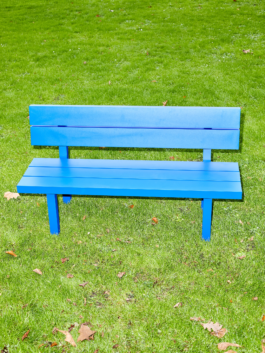 Big blue aluminium bench with backrest from the furniture series Pretending It's Wood. Placed on bright green grass. Designed by ErtlundZull. Photographed by Robert Hamacher. ErtlundZull